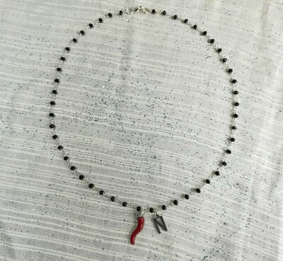 Collana girocollo stile rosario realizzata a mano con filo di colore oro cristalli di colore rosso e ciondolo portafortuna cornetto rosso. 
