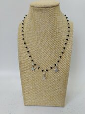 Collana girocollo stile rosario realizzata a mano con filo colore argento, cristalli neri e pendenti a forma di stella di colore argento.