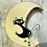 Luna in legno con gatto arrampicato che scivola