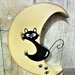 Luna in legno con gatto arrampicato che scivola
