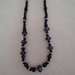 Elegante collana  realizzata a mano con perle nere tonde e sfaccettate alternate da pietre più grandi sfaccettate  di colore viola  con distanziatori formati da tondini di metallo e perle di color argento. 