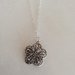 Catenina girocollo in argento 925 con catenella formata da tanti anelli ed impreziosita da un ciondolo a forma di  fiore.