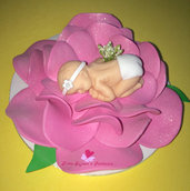 Cake topper a forma di fiore che avvolge un neonato. 