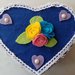Portagioie a forma di cuore rivestito da pannolenci color blu e impreziosito da roselline e al centro e cuoricini color viola con perla al centro. tutto i lcontorno èrivestito da merletto macramè .