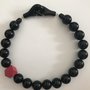 Collana girocollo con perle nere e componente in legno di colore rosso.