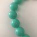 Collana girocollo con perle verdi e perla grigia più grande 