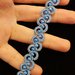 Bracciale al chiacchierino color azzurro con filo metallizzato e cristalli azzurri