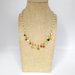 Collana girocollo stile rosario realizzata a mano di colore oro, cristalli rosa e ciondoli stelle e cuori colorati.