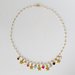 Collana girocollo stile rosario realizzata a mano di colore oro, cristalli rosa e ciondoli stelle e cuori colorati.