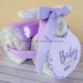 Torta pannolini, triciclo con biberon, completo culla, bavaglino, body e calzini neonato (lilla)