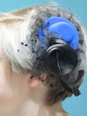 Accessorio per i capelli. Un fermaglio per una ragazza. A forma di cappello, con velo e piume.