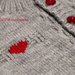 Golfino in pura lana merinos grigia con bottoncini rossi e cuoricini rossi ricamati a punto maglia