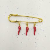 Spilla realizzata a mano colore oro con ciondoli cornetti rossi portafortuna. Spilla per cardigan, sciarpe, collo e foulard.
