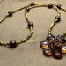 Collana con perle in legno marrone scuro, biconi acrilico color oro e perline conterie