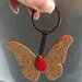 Farfalla portachiavi in pelle con perline in vetro e cordoncino macramè