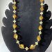 Collana con perle in vetro elicoidali con foglia color oro 