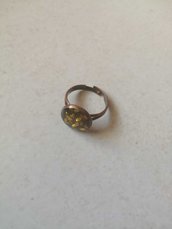 Anello colore oro trasparente con piccole pietre immerse nella resina