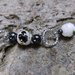 Bracciale con perle di ematite e perle bianche con decorazione floreale nera