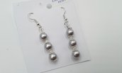 Orecchini pendenti con perle color grigio.