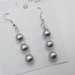 Orecchini pendenti con perle color grigio.