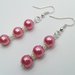 Orecchini pendenti con perle color rosa.