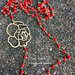 Collana lunga a rosario con cristalli rossi e fiore in zama 