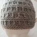 Cappello unisex realizzato a uncinetto con lana color grigio.