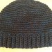 Originale cappello realizzato a uncinetto con lana nera e con filo azzurro.