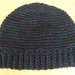 Originale cappello realizzato a uncinetto con lana nera e con filo azzurro.