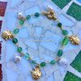 Bracciale a rosario con pietre dure verdi, ciondoli coccinella in zama e perle di fiume