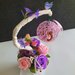 Vaso, rose di sapone rosa e viola con ramo e nido di uccello