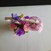 Vaso, rose di sapone rosa e viola con ramo e nido di uccello