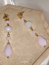 Orecchini pendenti con perno stella dorata, mezzi cristalli bianco satinato, rosa opalescente e goccia di vetro rosa satinato.