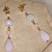 Orecchini pendenti con perno stella dorata, mezzi cristalli bianco satinato, rosa opalescente e goccia di vetro rosa satinato.