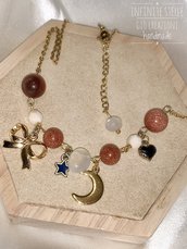 Collana luminosa regolabile in acciaio dorato con Pietre del Sole caramello, Pietra della Luna, charms fiocco, luna e stella.