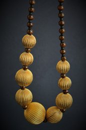 Collana stile etnico con perline in legno e grandi perle dorate in lega metallica