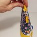 Pochette fantasia fiori e gialla con decorazione con piccole nappine e zip