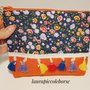 Pochette fantasia fiori e arancione con decorazione con piccole nappine e zip