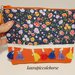 Pochette fantasia fiori e arancione con decorazione con piccole nappine e zip