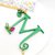 Collana lunga con catenina dorata e lettera M verde pendente, decorata con perle di vetro