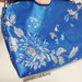 Borsetta blu stoffa brillante con fiori in lamet, cerniera e tracollina