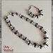 Set di collana e bracciale realizzato interamente a mano ad uncinetto, con perle bianche e mezzi cristalli di colore argento e nero