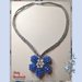 Collana con ciondolo realizzata ad uncinetto con filato gioiello di colore argento e mezzi cristalli azzurri