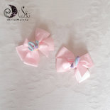 due fermacapelli a pinza con fiocco rosa decorati con dolcetti ciambella e marshmallow
