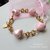 Bracciale in alluminio dorato e cuoricini in ceramica rosa