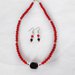       Collana e orecchini con perle rosse e perla nera centrale