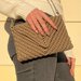 Pochette foderata dorata in cordino lurex lavorato all'uncinetto con motivo geometrico