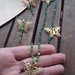 Parure collana orecchini pendenti con cristalli verdi e farfalle in ottone 