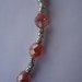 collana con perle in resina sfaccettate di varie dimensioni, perline in metallo e catene