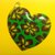 Ciondolo in fimo a forma di cuore su base verde con fiori nei toni del giallo e viola